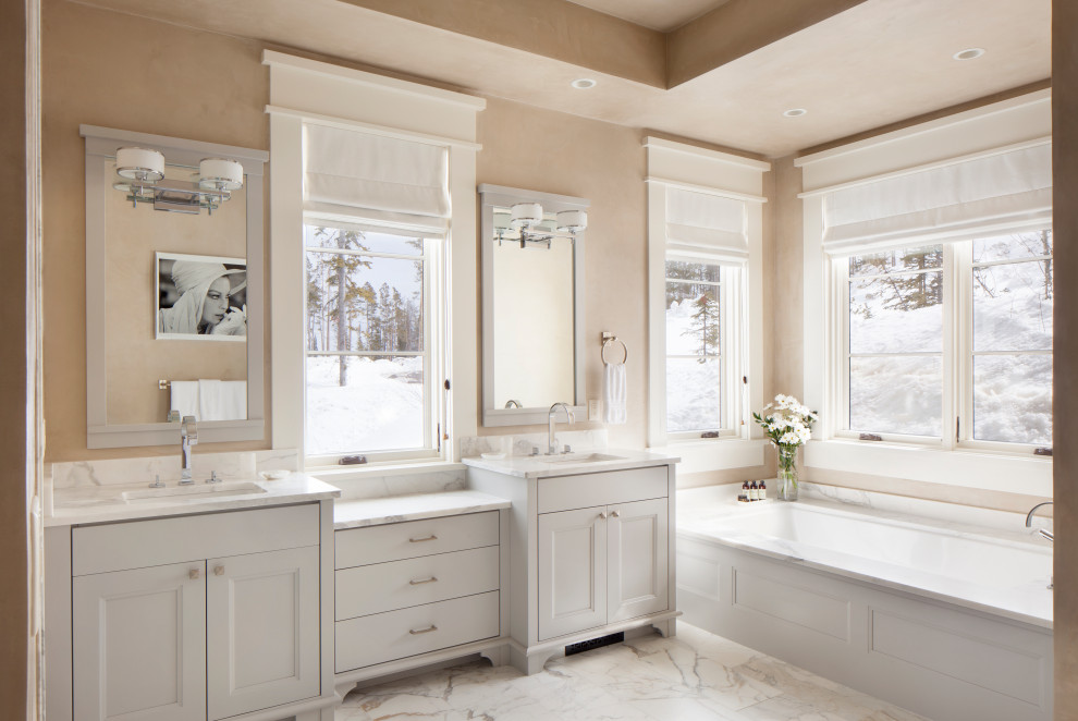 Rustik inredning av ett vit vitt en-suite badrum, med luckor med infälld panel, vita skåp, beige väggar och ett undermonterad handfat