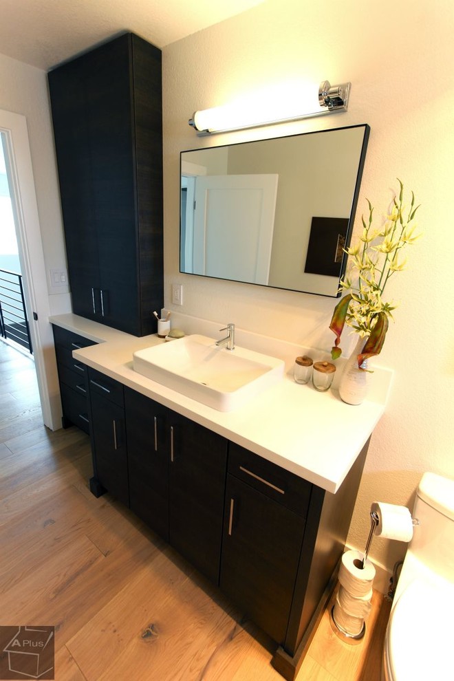 This is an example of a small modern shower room bathroom in Orange County with a vessel sink, flat-panel cabinets, dark wood cabinets, quartz worktops, a two-piece toilet, beige tiles, porcelain tiles, beige walls and light hardwood flooring.