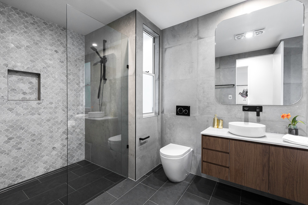 Inspiration för moderna vitt badrum med dusch, med släta luckor, skåp i mörkt trä, en dusch i en alkov, en toalettstol med hel cisternkåpa, grå väggar, ett fristående handfat, grått golv och med dusch som är öppen