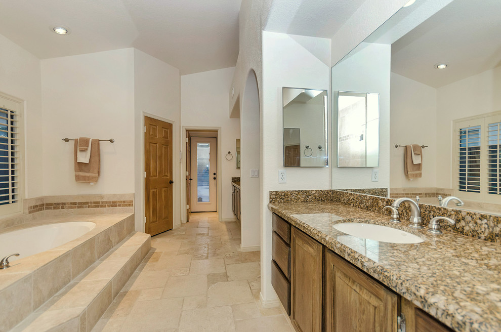 Mid-sized transitional master beige tile travertine floor bathroom photo in Phoenix with an undermount sink, raised-panel cabinets, medium tone wood cabinets, granite countertops, a two-piece toilet and beige walls