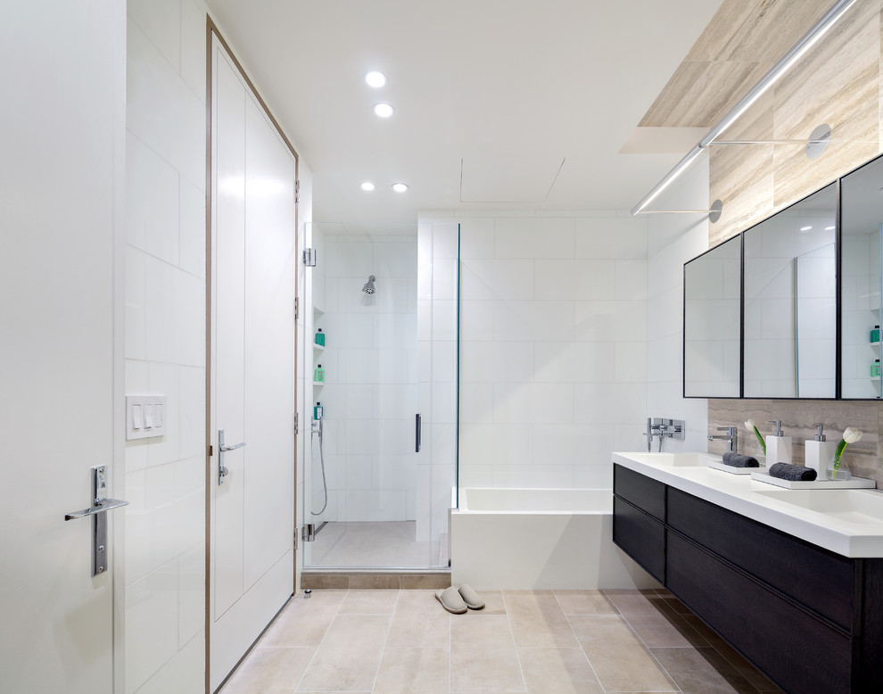 Contemporary ensuite bathroom in New York with flat-panel cabinets, dark wood cabinets, an alcove bath, a corner shower, beige tiles, white tiles, white walls and a hinged door.