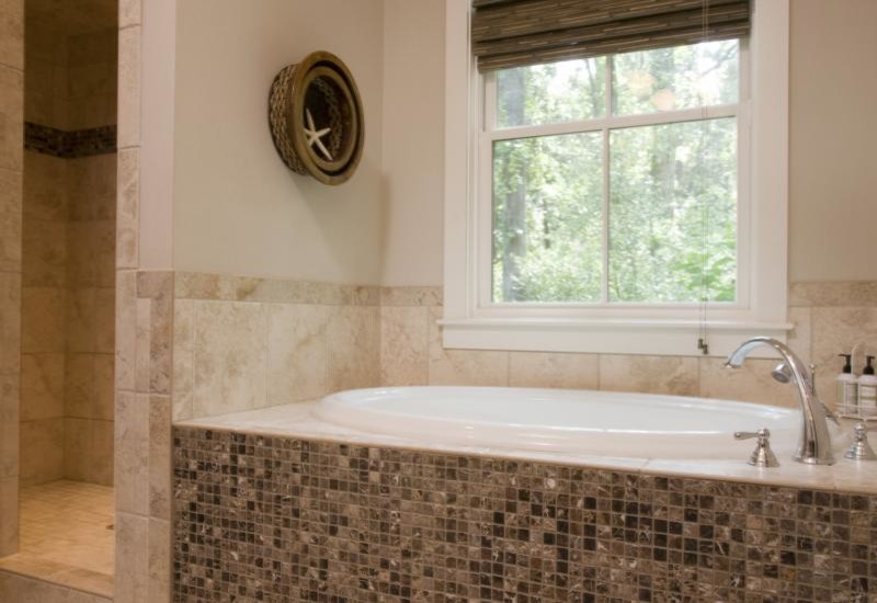 Foto på ett vintage badrum, med ett platsbyggt badkar, en dusch i en alkov, beige kakel, stenkakel och beige väggar