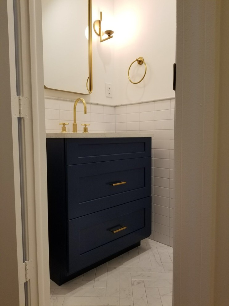 Inspiration for a small contemporary shower room bathroom in New York with shaker cabinets, blue cabinets, a wall mounted toilet, white tiles, metro tiles, white walls, porcelain flooring, a submerged sink and engineered stone worktops.