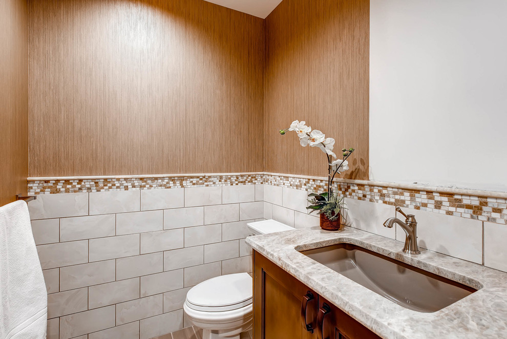 Bild på ett mellanstort funkis badrum, med luckor med infälld panel, skåp i mellenmörkt trä, en toalettstol med separat cisternkåpa, mosaik, vita väggar, klinkergolv i keramik, ett undermonterad handfat och bänkskiva i kvartsit