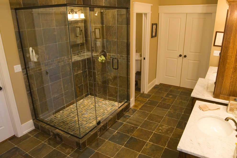 Example of a large arts and crafts multicolored tile and stone tile slate floor alcove shower design in Chicago with an undermount sink, flat-panel cabinets, medium tone wood cabinets, marble countertops, a two-piece toilet and beige walls