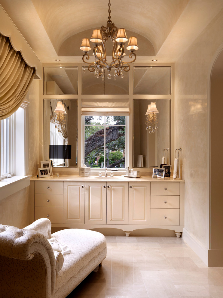 Design ideas for an expansive traditional bathroom in Tampa with a submerged sink, raised-panel cabinets, white cabinets, marble worktops, beige tiles, stone tiles and limestone flooring.