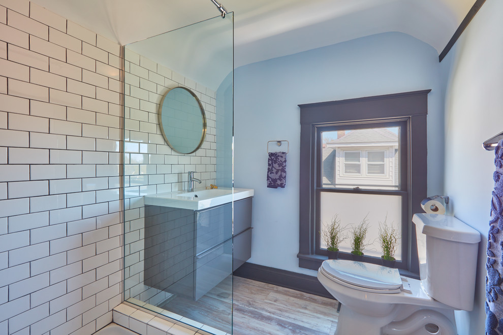 Свежая идея для дизайна: ванная комната среднего размера в современном стиле с плоскими фасадами, серыми фасадами, угловым душем, раздельным унитазом, белой плиткой, керамической плиткой, синими стенами, полом из ламината, душевой кабиной, монолитной раковиной, столешницей из искусственного камня, бежевым полом и открытым душем - отличное фото интерьера