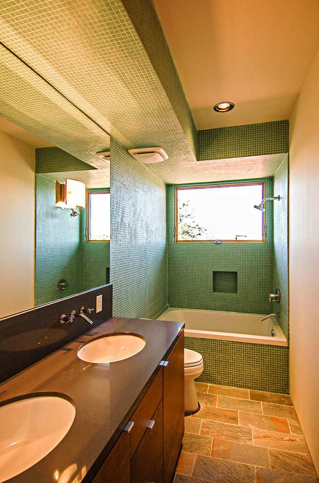 Modern inredning av ett mellanstort en-suite badrum, med ett undermonterad handfat, släta luckor, skåp i mörkt trä, bänkskiva i kvarts, ett badkar i en alkov, en dusch/badkar-kombination, en toalettstol med separat cisternkåpa, grön kakel, mosaik, vita väggar och klinkergolv i porslin