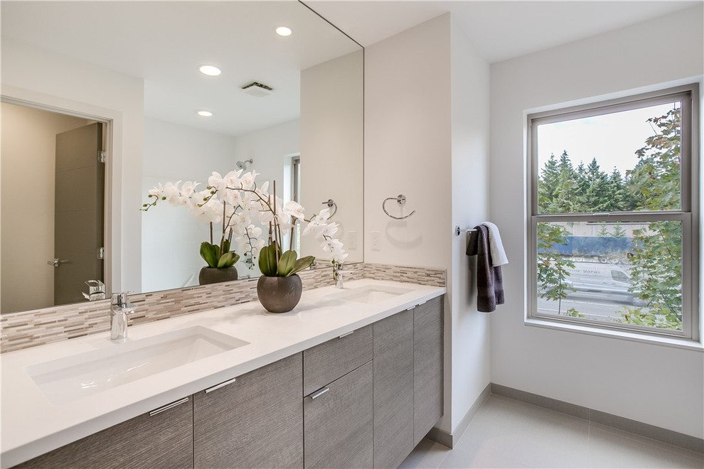 Imagen de cuarto de baño moderno con armarios con paneles lisos, bañera empotrada y ducha empotrada