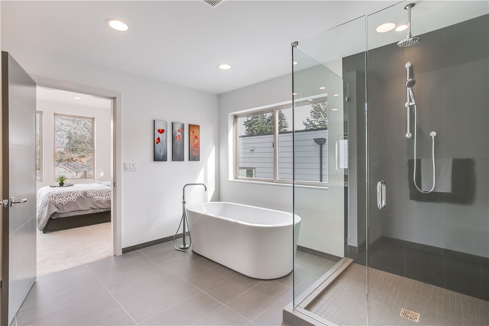 This is an example of a modern ensuite bathroom in Seattle with a freestanding bath and a corner shower.