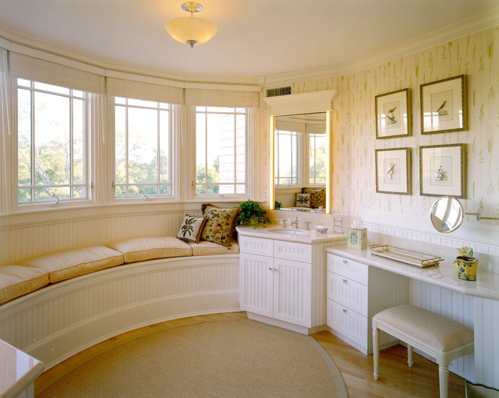 На фото: ванная комната в классическом стиле с врезной раковиной, белыми фасадами и зеркалом с подсветкой