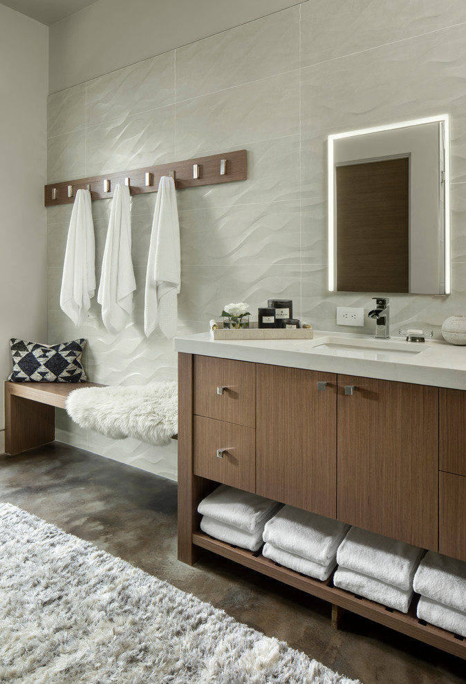 На фото: ванная комната в современном стиле с плоскими фасадами, темными деревянными фасадами, серой плиткой, белыми стенами, бетонным полом, врезной раковиной, серым полом, белой столешницей и зеркалом с подсветкой с
