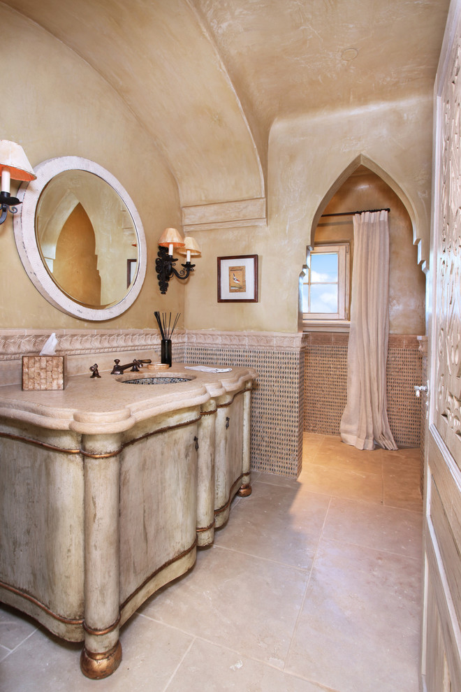 Idées déco pour une salle de bain méditerranéenne avec un lavabo encastré, des portes de placard beiges, un mur beige et une fenêtre.