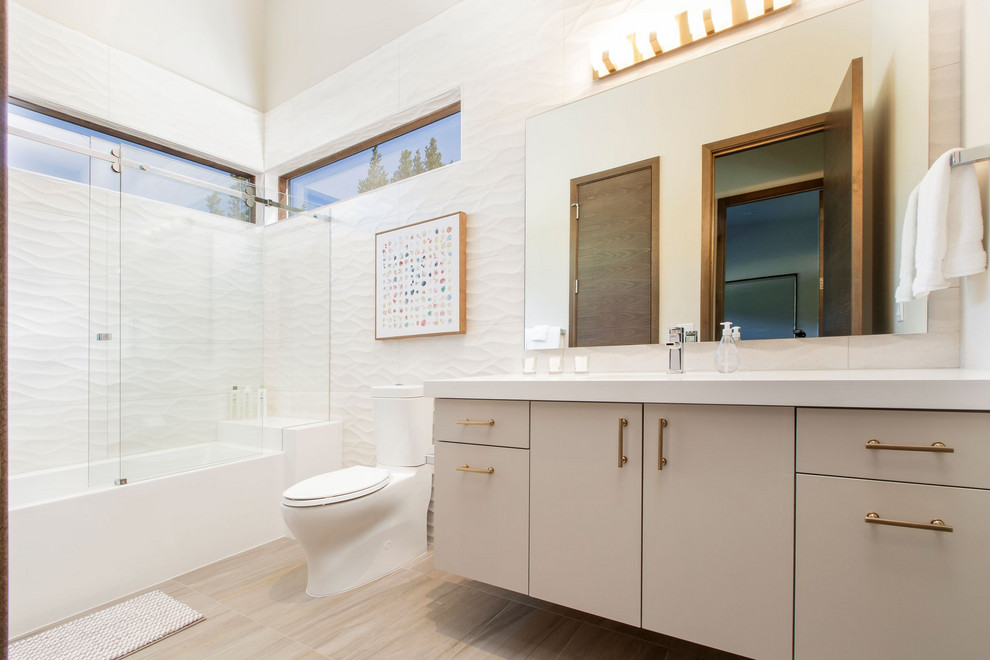 Inspiration for a medium sized contemporary family bathroom in Denver with flat-panel cabinets, white cabinets, a shower/bath combination, white tiles, white floors, a sliding door and white worktops.