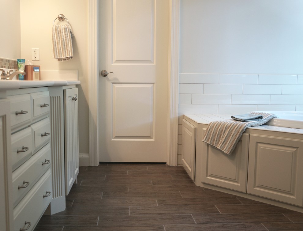 Inredning av ett lantligt mellanstort badrum, med luckor med upphöjd panel, grå skåp, marmorbänkskiva, ett platsbyggt badkar, en hörndusch, grå kakel, porslinskakel, vita väggar och klinkergolv i porslin