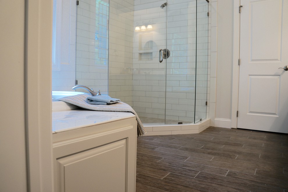 Inspiration pour une salle de bain rustique de taille moyenne avec un placard avec porte à panneau surélevé, des portes de placard grises, un plan de toilette en marbre, une baignoire posée, une douche d'angle, un carrelage gris, des carreaux de porcelaine, un mur blanc et un sol en carrelage de porcelaine.