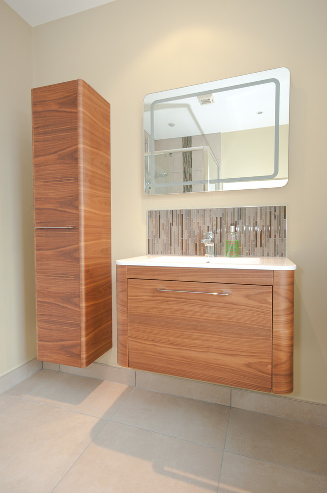 Inspiration for a large contemporary ensuite bathroom in Belfast with medium wood cabinets, a freestanding bath, a walk-in shower, a wall mounted toilet, beige tiles and porcelain flooring.