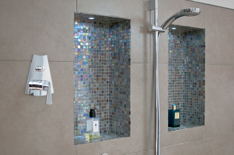 Imagen de cuarto de baño principal actual grande con puertas de armario de madera oscura, bañera exenta, ducha abierta, sanitario de pared, baldosas y/o azulejos beige y suelo de baldosas de porcelana
