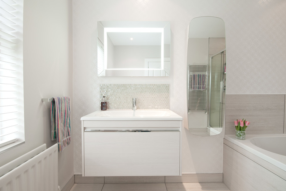ベルファストにある高級な広いコンテンポラリースタイルのおしゃれなマスターバスルーム (中間色木目調キャビネット、置き型浴槽、オープン型シャワー、壁掛け式トイレ、ベージュのタイル、磁器タイルの床) の写真