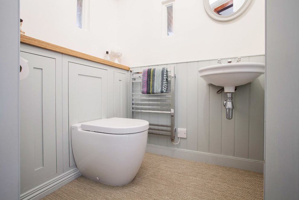 Small rural family bathroom in Kent with grey cabinets, a wall mounted toilet, white walls, vinyl flooring, a wall-mounted sink, beige floors, shaker cabinets and wooden worktops.