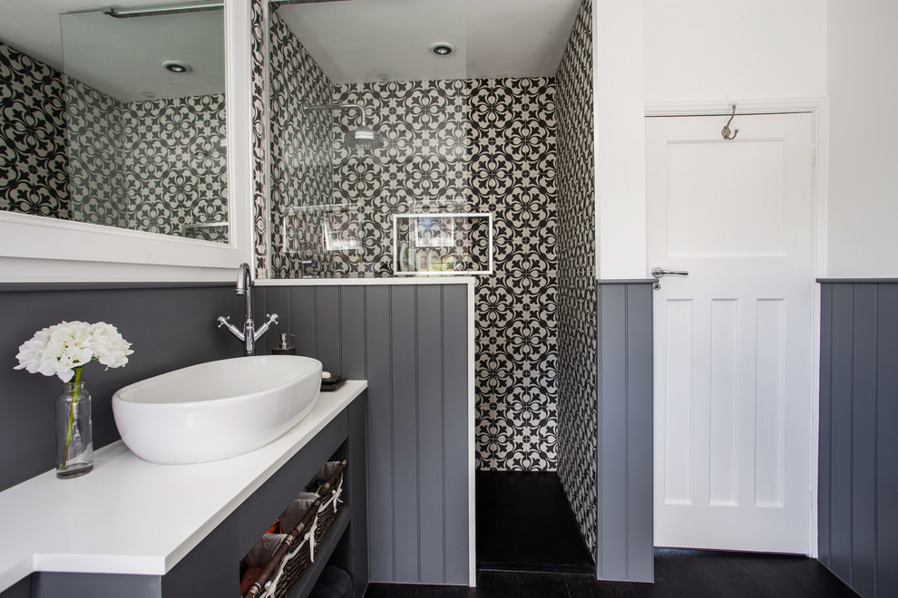 Photo of a medium sized contemporary family bathroom in Kent with flat-panel cabinets, grey cabinets, a freestanding bath, a corner shower, a wall mounted toilet, black and white tiles, white walls, dark hardwood flooring, a built-in sink, quartz worktops, an open shower and white worktops.