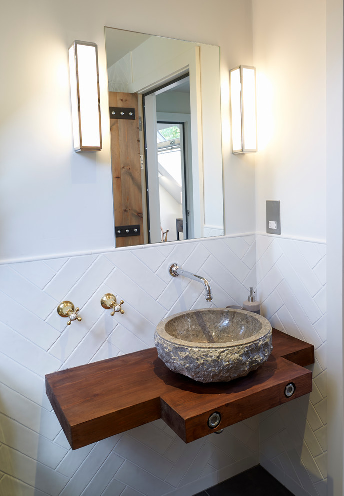 Bild på ett litet funkis en-suite badrum, med en öppen dusch, en toalettstol med separat cisternkåpa, svart och vit kakel, keramikplattor, vita väggar, klinkergolv i keramik, ett fristående handfat och träbänkskiva