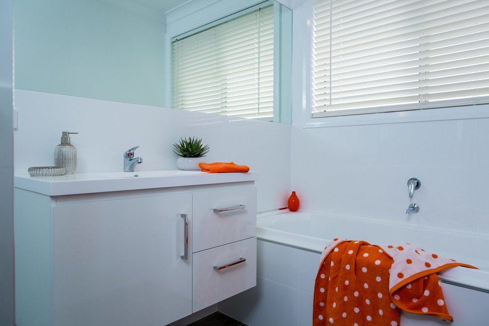 Foto di una piccola stanza da bagno per bambini moderna con ante bianche, vasca da incasso, piastrelle marroni, pareti bianche e lavabo da incasso