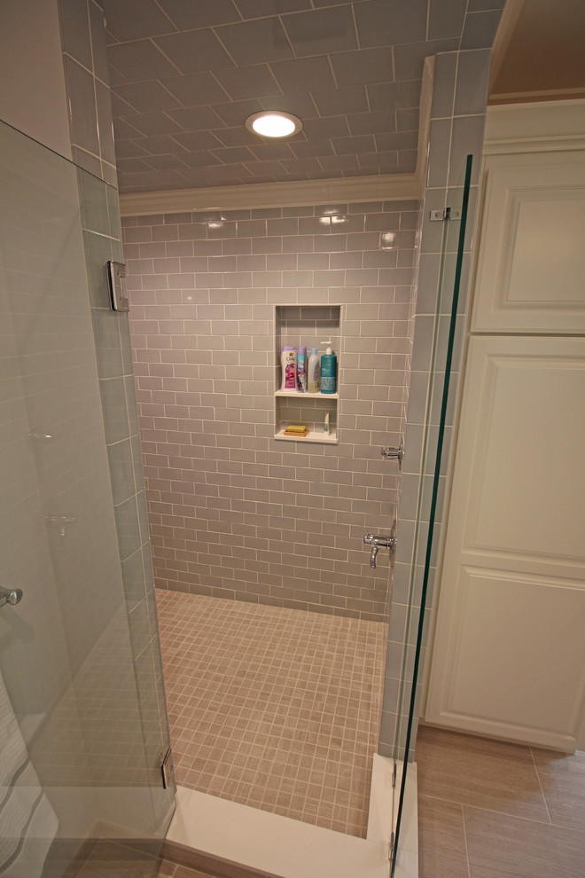 Mid-sized elegant master gray tile and ceramic tile ceramic tile and beige floor alcove shower photo in Detroit with raised-panel cabinets, white cabinets, a two-piece toilet, gray walls, an undermount sink, quartz countertops and a hinged shower door