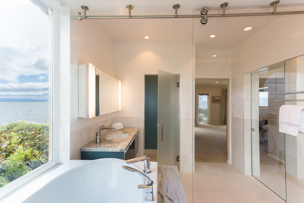 Modern inredning av ett stort en-suite badrum, med släta luckor, blå skåp, ett hörnbadkar, en öppen dusch, en bidé, porslinskakel, vita väggar, klinkergolv i porslin, ett undermonterad handfat, granitbänkskiva och dusch med skjutdörr