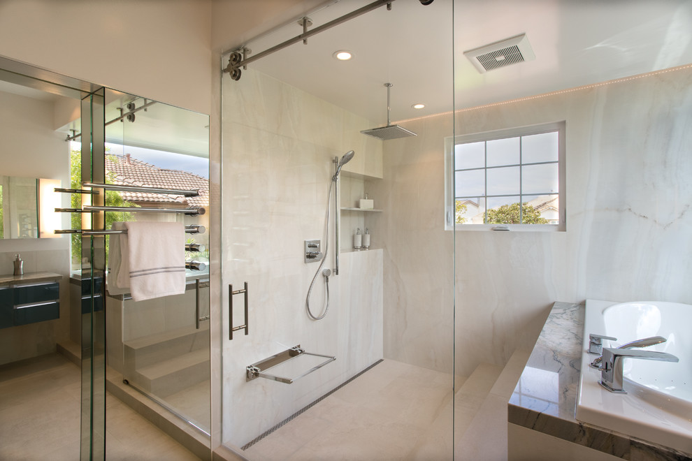Exempel på ett stort modernt en-suite badrum, med släta luckor, blå skåp, ett platsbyggt badkar, en öppen dusch, vit kakel, porslinskakel, vita väggar, granitbänkskiva och dusch med skjutdörr