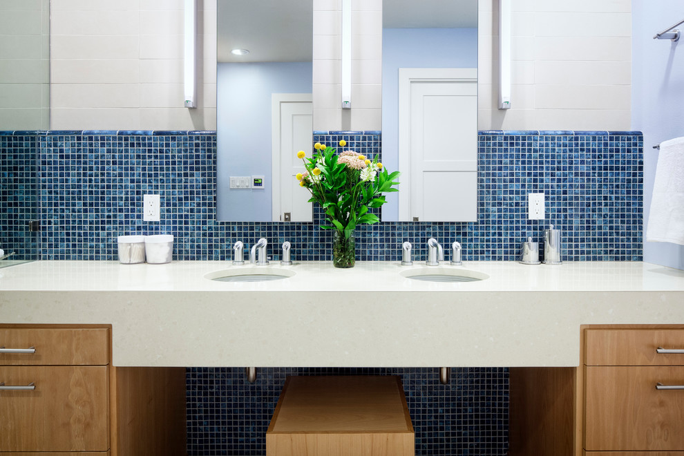 Foto di una stanza da bagno padronale minimal con lavabo sottopiano, top in superficie solida, piastrelle blu, piastrelle in gres porcellanato, pavimento in gres porcellanato e pareti bianche