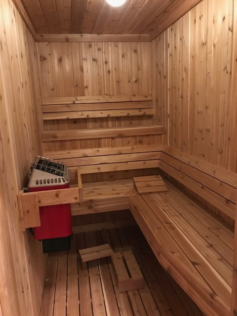 Immagine di una sauna stile rurale di medie dimensioni con zona vasca/doccia separata, pareti beige, parquet chiaro e pavimento beige