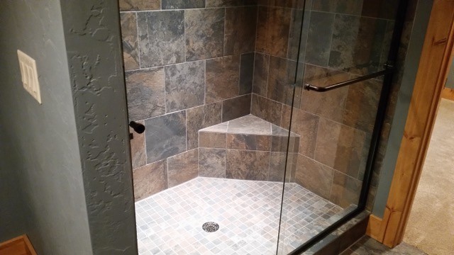 На фото: ванная комната в стиле рустика с душем в нише, раздельным унитазом, коричневой плиткой, серой плиткой, керамической плиткой, серыми стенами, полом из керамической плитки, душевой кабиной, коричневым полом и душем с раздвижными дверями с