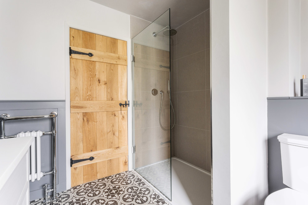 Photo of a medium sized contemporary family bathroom in Kent with beaded cabinets, beige cabinets, a freestanding bath, a walk-in shower, a two-piece toilet, white walls, cement flooring, a submerged sink, granite worktops, multi-coloured floors and an open shower.
