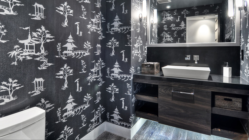 Large modern bathroom in Orange County with a trough sink, flat-panel cabinets, black cabinets, a one-piece toilet, black walls and dark hardwood flooring.