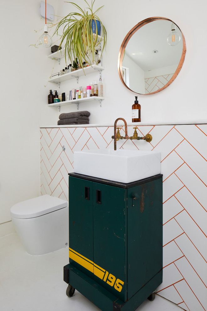 This is an example of an eclectic bathroom in London with flat-panel cabinets, green cabinets, white tiles, white walls, a vessel sink and white floors.