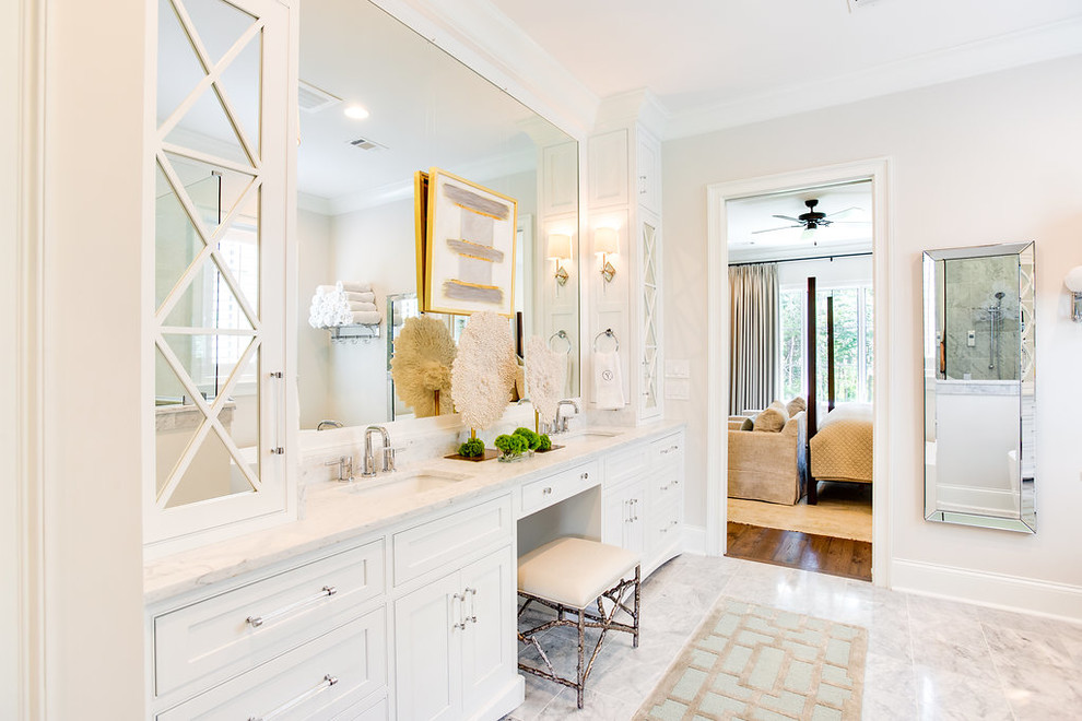 Inredning av ett klassiskt stort vit vitt en-suite badrum, med luckor med profilerade fronter, vita skåp, ett fristående badkar, en hörndusch, vit kakel, marmorkakel, vita väggar, marmorgolv, ett undermonterad handfat, marmorbänkskiva, gult golv och dusch med gångjärnsdörr