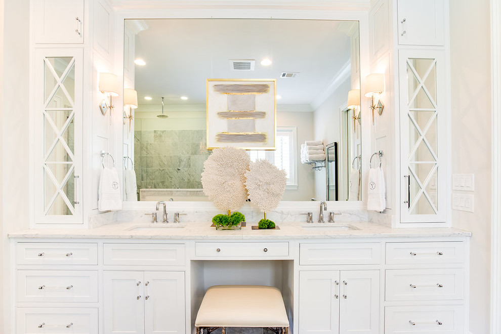 Klassisk inredning av ett stort vit vitt en-suite badrum, med luckor med profilerade fronter, vita skåp, ett fristående badkar, en hörndusch, vit kakel, marmorkakel, vita väggar, marmorgolv, ett undermonterad handfat, marmorbänkskiva, gult golv och dusch med gångjärnsdörr