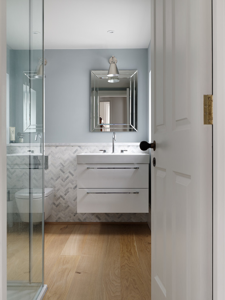 Photo of a small contemporary shower room bathroom in Sussex with flat-panel cabinets, white cabinets, a freestanding bath, a walk-in shower, a wall mounted toilet, white walls, light hardwood flooring, a console sink, tiled worktops, brown floors, a sliding door and grey worktops.