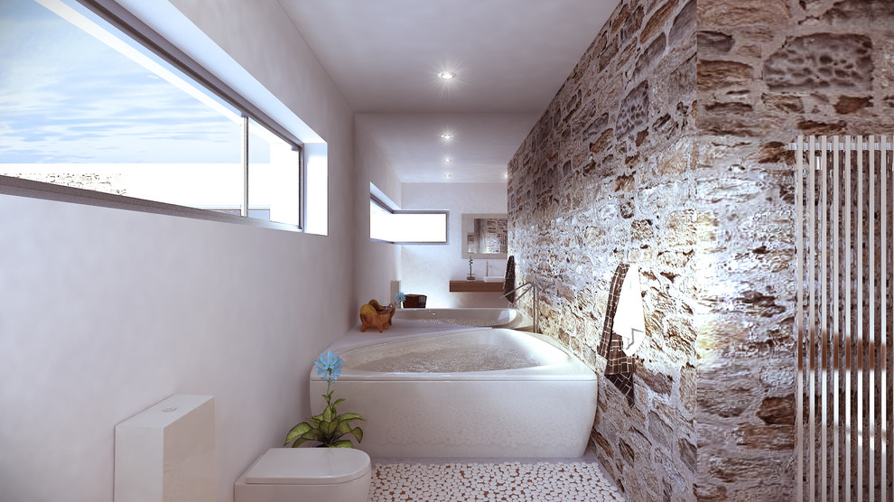 Réalisation d'une grande salle de bain principale chalet avec un bain bouillonnant, un combiné douche/baignoire, WC suspendus, un mur blanc, une vasque et un plan de toilette en bois.