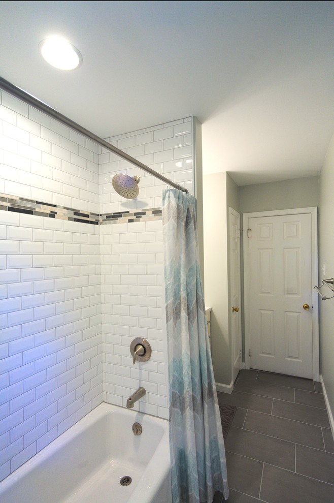 Idéer för små amerikanska badrum, med möbel-liknande, vita skåp, ett badkar i en alkov, en dusch/badkar-kombination, en toalettstol med separat cisternkåpa, vit kakel, keramikplattor, grå väggar, klinkergolv i porslin, ett undermonterad handfat och bänkskiva i kalksten