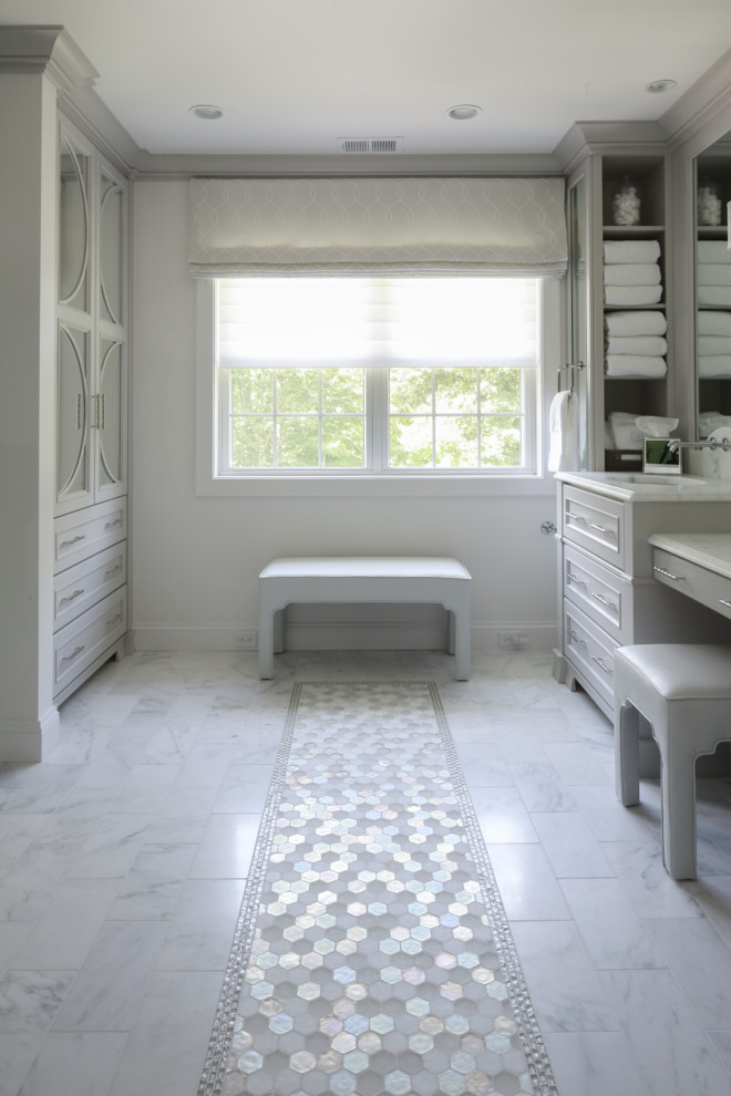 Cette photo montre une grande salle de bain principale chic avec un placard à porte plane, des portes de placard grises, une douche double, WC séparés, un carrelage de pierre, un mur gris, un sol en marbre, un lavabo encastré et un plan de toilette en marbre.
