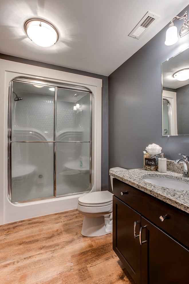 Idéer för mellanstora funkis badrum med dusch, med skåp i mörkt trä, en dusch i en alkov, vit kakel, grå väggar, ljust trägolv och granitbänkskiva