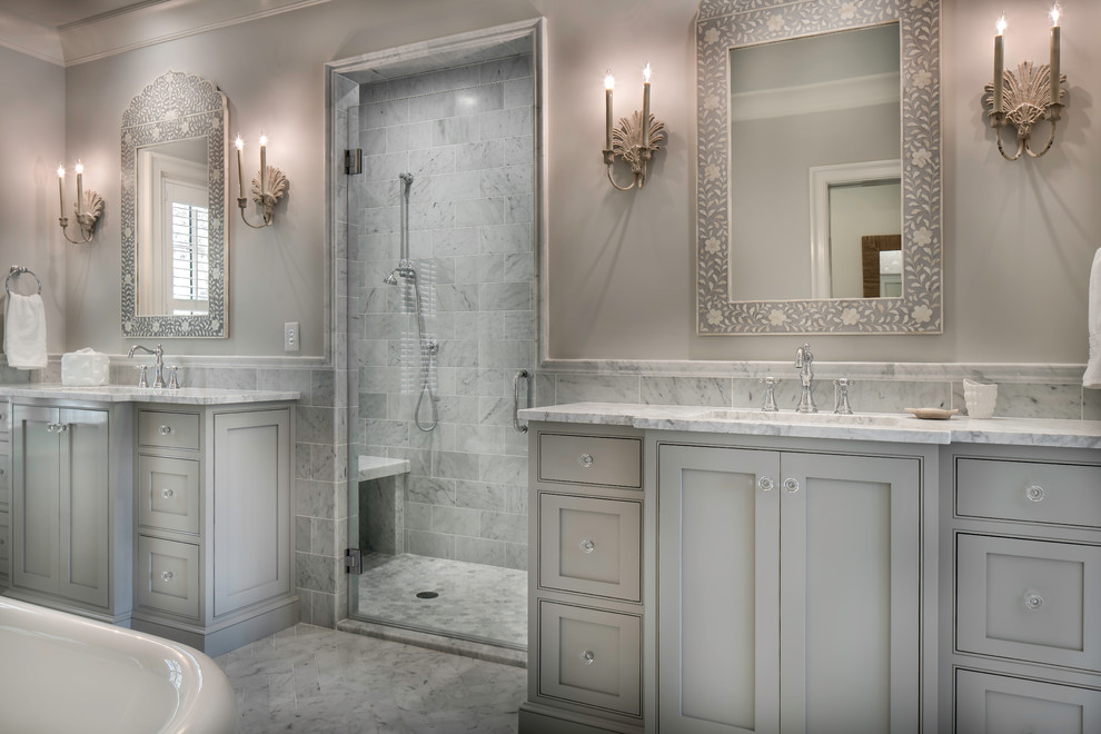 Exemple d'une douche en alcôve principale chic avec un placard à porte affleurante, des portes de placard grises, une baignoire sur pieds, un lavabo posé et un plan de toilette en marbre.