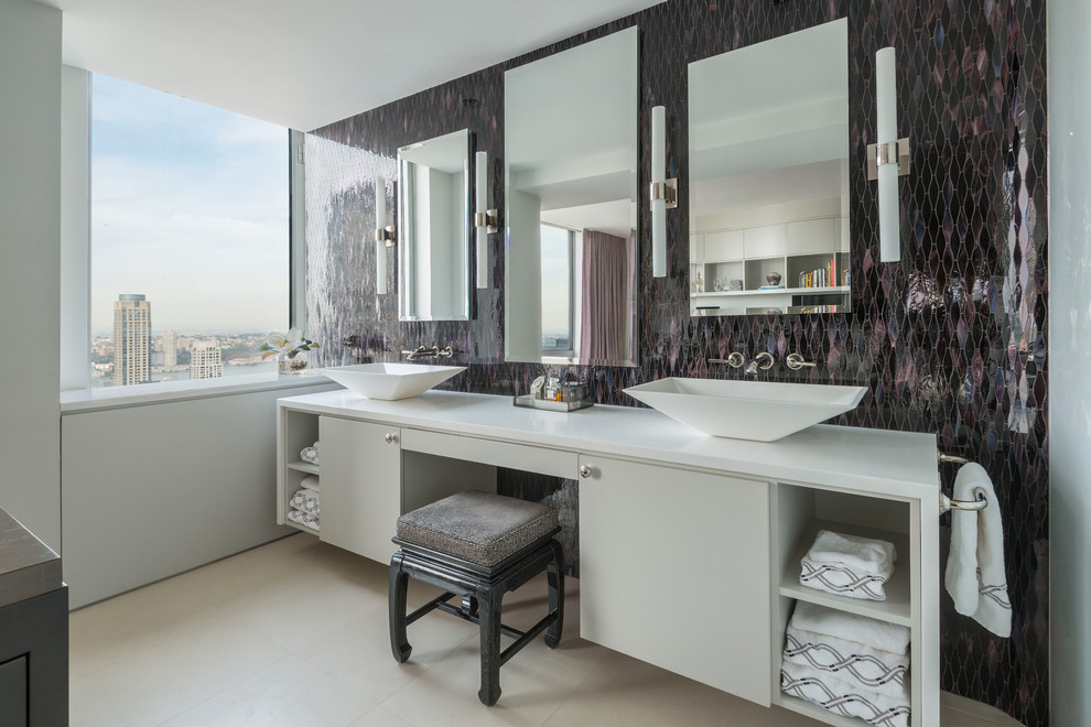 Cette image montre une grande salle de bain principale design avec un placard à porte plane, des portes de placard blanches, mosaïque, une vasque, un sol beige, un mur violet, un sol en calcaire et un plan de toilette en surface solide.