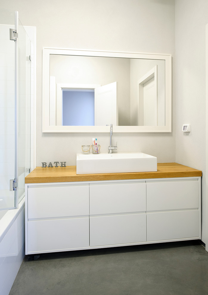 Inspiration pour une salle de bain design avec une vasque et un plan de toilette en bois.