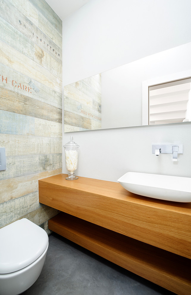 Ejemplo de cuarto de baño contemporáneo con lavabo sobreencimera y sanitario de pared