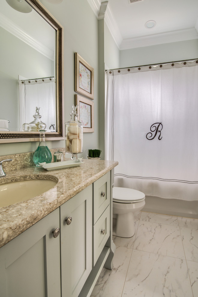 На фото: ванная комната среднего размера в стиле неоклассика (современная классика) с фасадами в стиле шейкер, серыми фасадами, ванной в нише, душем над ванной, унитазом-моноблоком, белой плиткой, керамогранитной плиткой, серыми стенами, мраморным полом, душевой кабиной, врезной раковиной, столешницей из гранита, белым полом и шторкой для ванной с