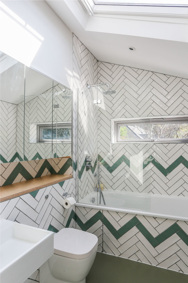 Modelo de cuarto de baño principal contemporáneo con bañera empotrada, combinación de ducha y bañera, sanitario de una pieza, lavabo suspendido, suelo verde, ducha abierta y paredes multicolor
