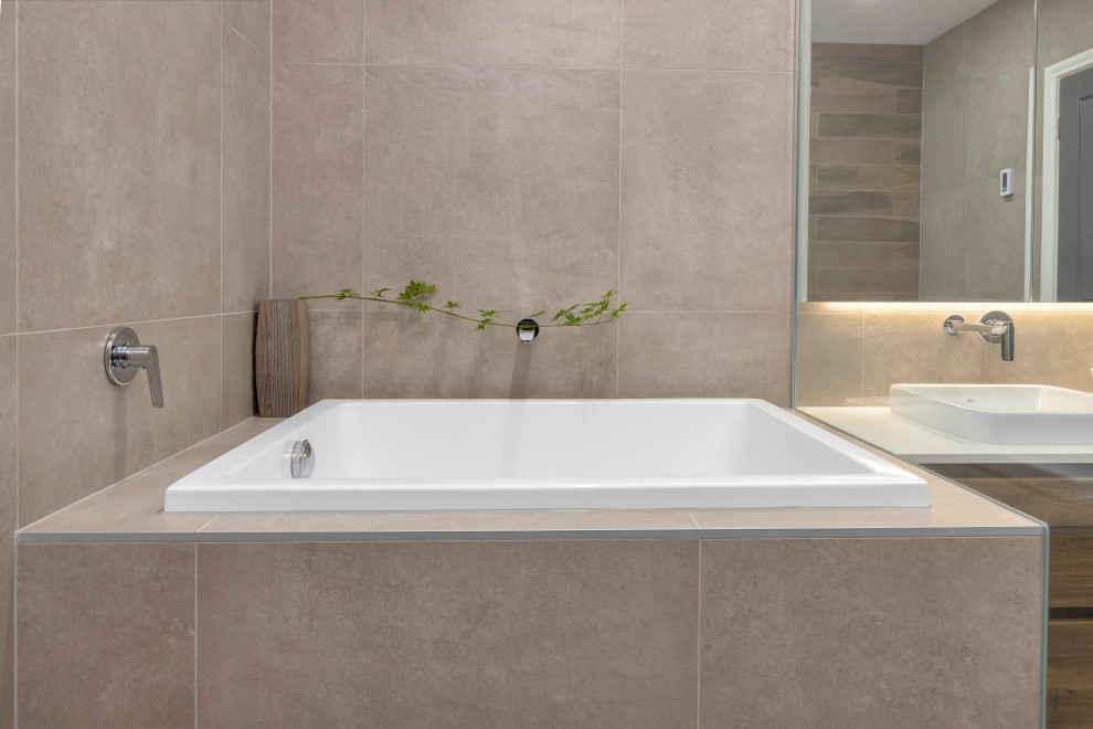 Inspiration for a large contemporary ensuite wet room bathroom in Melbourne with flat-panel cabinets, medium wood cabinets, a japanese bath, beige tiles, porcelain tiles, porcelain flooring, beige floors, an open shower, double sinks, a floating vanity unit, a vessel sink, engineered stone worktops, white worktops and a shower bench.